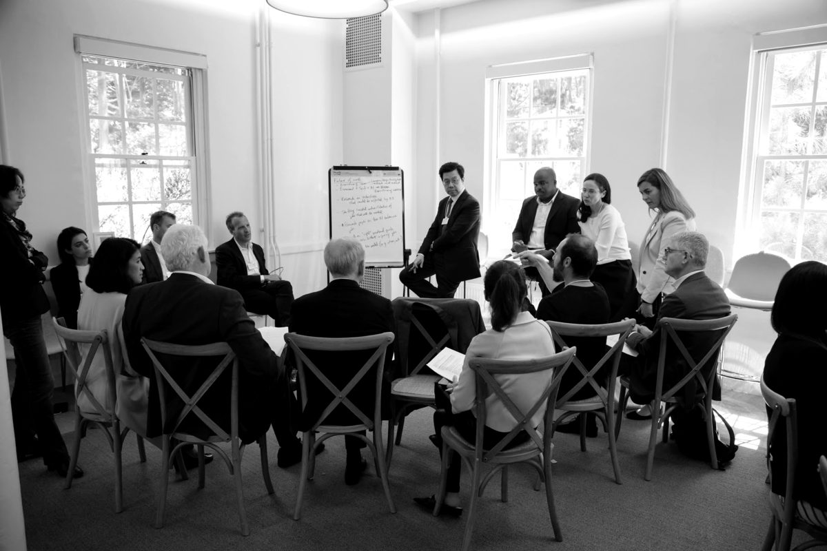 A working group seated in a circle around a flipchart discussing AI and the future of work